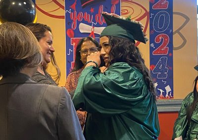 A graduate wearing green gown and hat at Clinitrack graduation